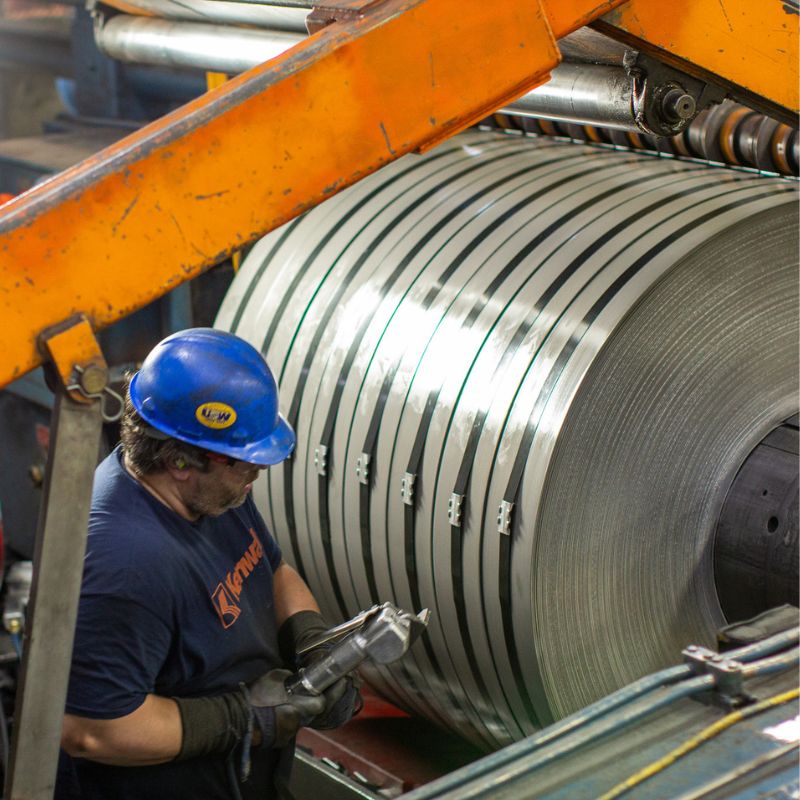 A Kenwal Burns Harbor steel plant worker conducting quality checks on a flat-rolled steel coil.